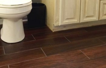 Tile that looks like hardwood in our guest bathroom: We knew we wanted tile in our bathroom, and these tile boards fit the bill. They're beautiful, sleek, and perfect for any bathroom. You'd never know they're tile until you step on them in bare feet! Click to read more about our selection and installation process.