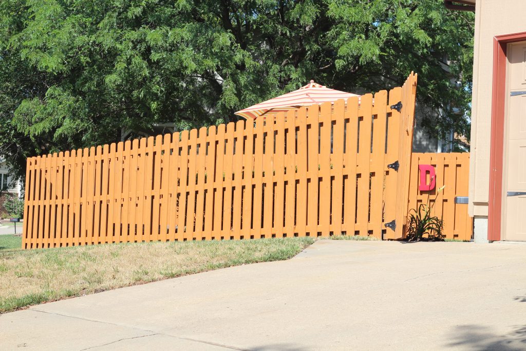 How to stain a fence: This post details what steps and materials we took and used to transform the look and condition of our wood fence. We did pressure washing, spray painting, painting, and more. The project was inexpensive, easy, and dramatic in effect. Anyone could do it! Click here to read more and get started on your fence!