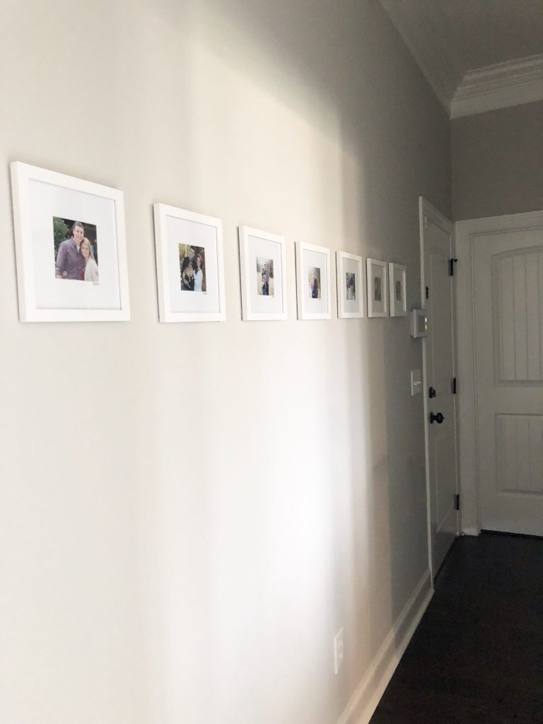 This family photo wall displays a simple arrangement of gallery-style images that shows the family in one photo each year. This hallway collage provides sentimental decor that will be meaningful for years to come. Click here for a full list of sources so that you can get going on creating this affordable, fast, and treasured wall for your family to enjoy.