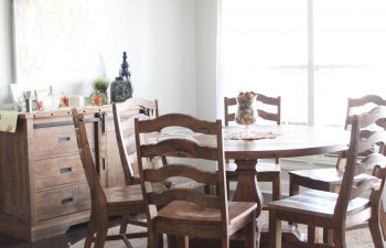 We love this family kitchen eating area! In this post, I share details about our new 54" round kitchen table, our 8' round jute rug, matching sideboard, curtains, rods, and more. Gather new ideas and inspiration for big or small kitchens. This specific round table area is near a window with a big wall for decorating. Click here to read more and get links to resources.
